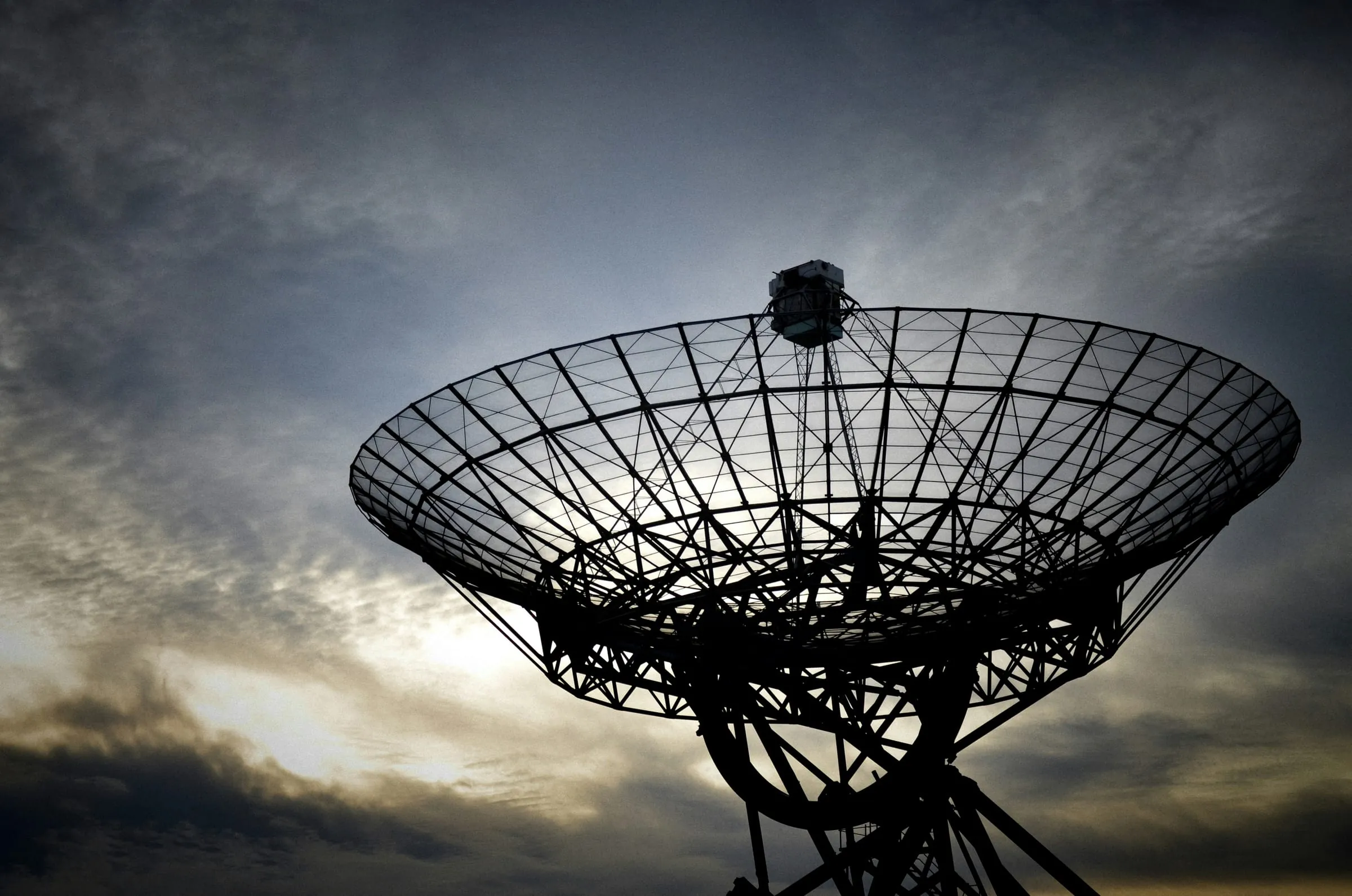 Large satellite dish silhouetted against the sky